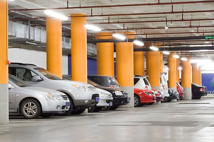 A row of cars parked in an underground parking lot